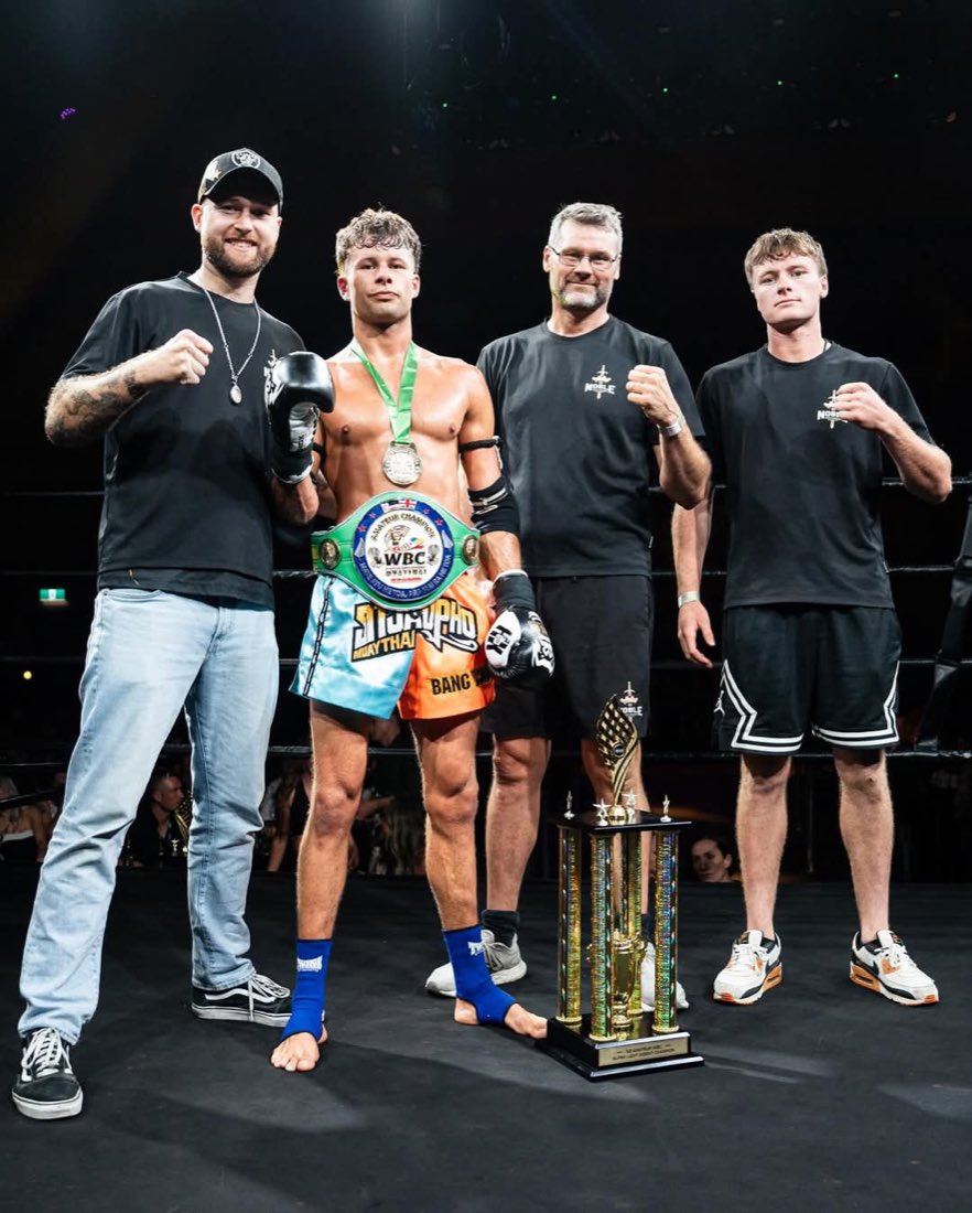 Noble Fight coaches with their fighter and a title belt in the ring