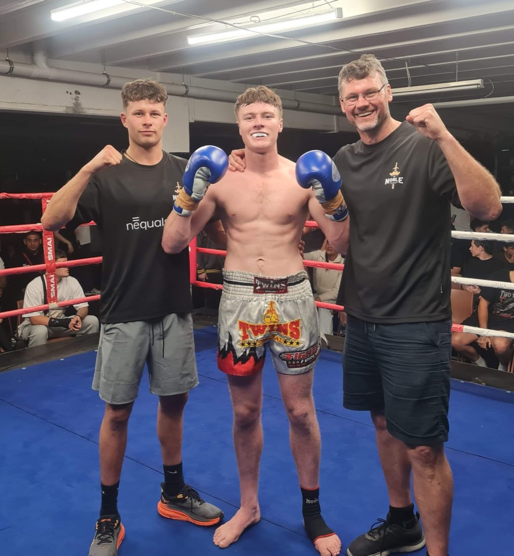 A young Noble Fight fighter with his coaches after a bout